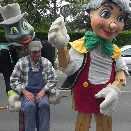 Pinocchio géant avec criquet géant portant geppetto